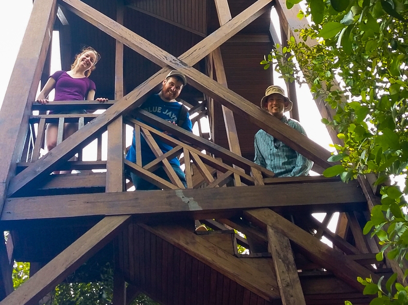 Myself, Brad, and Erik lean stand on the stairs of a wooden tower smiling down over the railing.